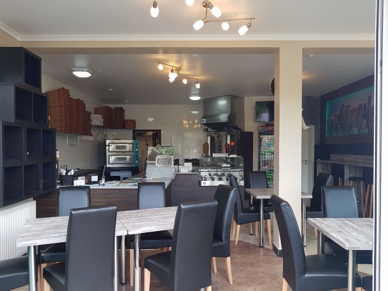 Gastraum der Pizzeria Napoli mit offener Küche und Pizzaofen