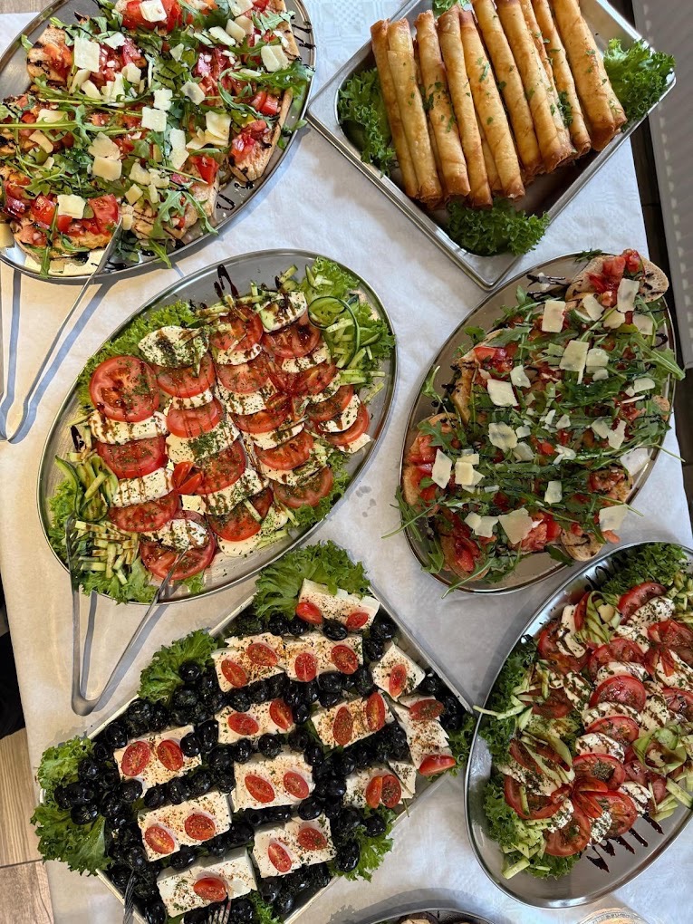 Bruschetta-Pizzen, Caprese und frittierte Teigrollen auf Catering-Platten