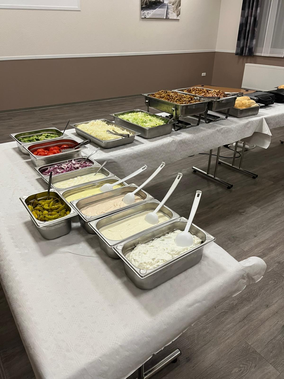 Döner-Beilagenbar mit Salaten, Käse und Saucen am Buffet